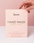 A pink packet with a hand mask inside that reads, "Karuna Hand Mask Hydrating + Treatment".