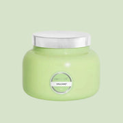 A green glass jarred candle with a silver lid.