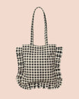 A black and white gingham print tote bag with ruffle details and shoulder straps.