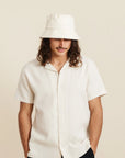 An ivory bucket hat worn on a model.