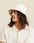An ivory bucket hat worn on a model.
