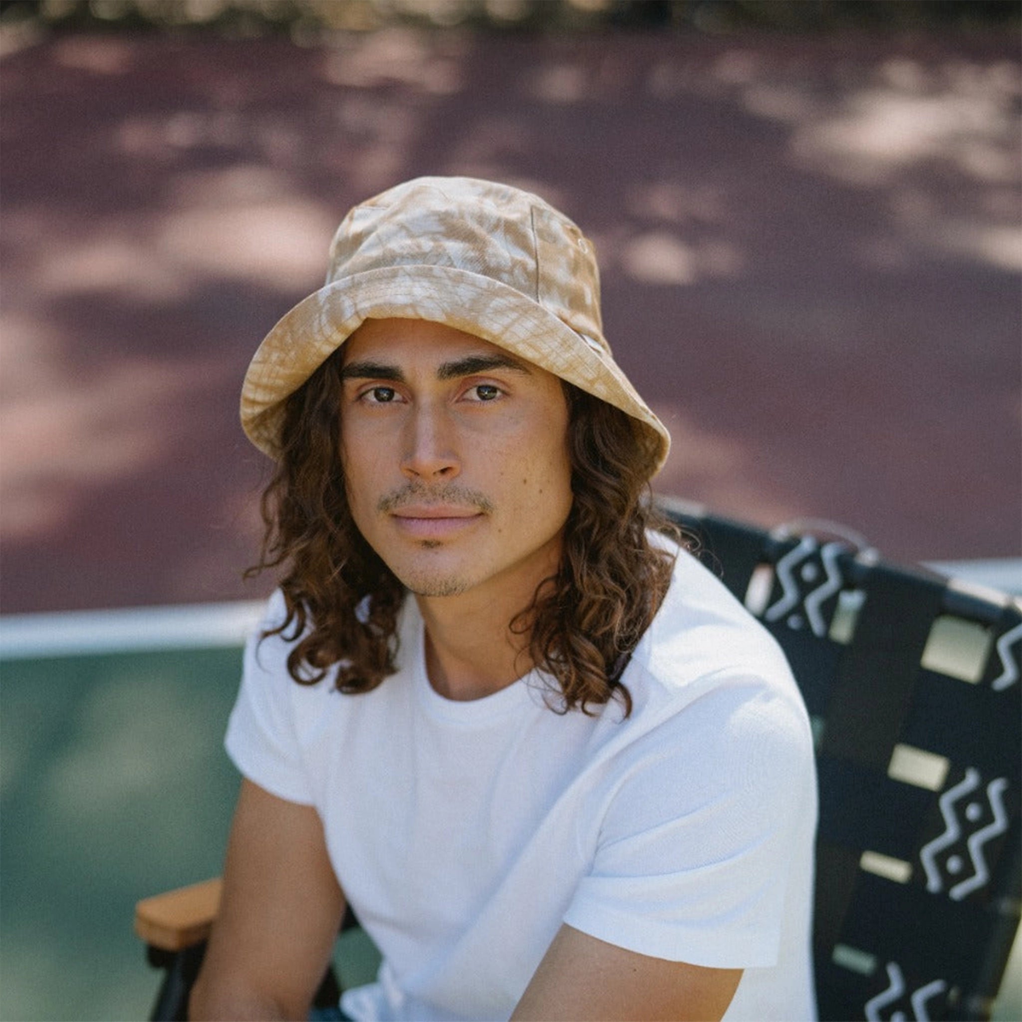 An ivory and tan bucket hat worn on a model.