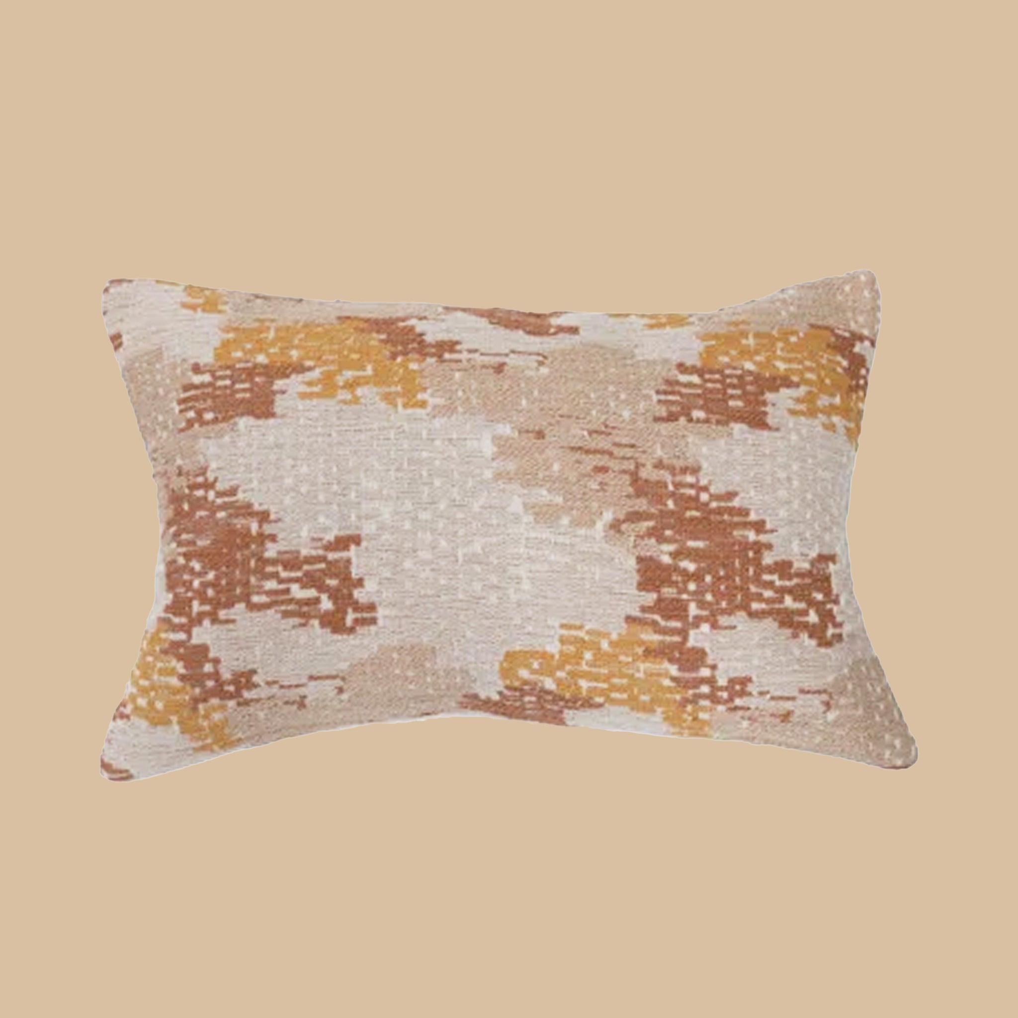 On a tan background is a lumbar pillow with a tan, burnt orange and rust colored design on it.
