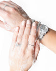 A model washing their hands and jewelry with the soap.