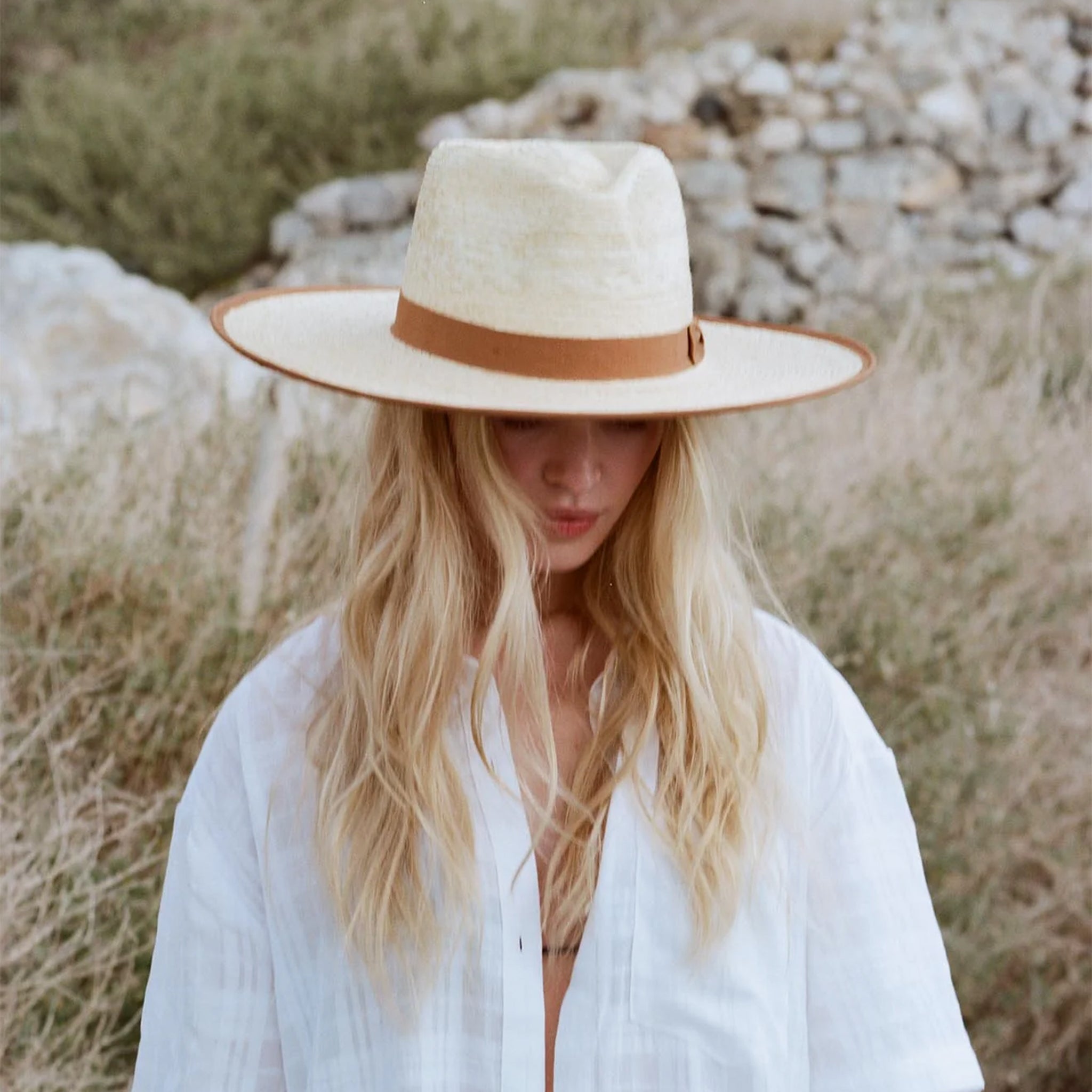 A neutral tan and natural colored rancher hat. 
