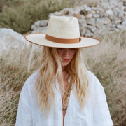 A neutral tan and natural colored rancher hat. 