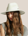 An off white felt hat with a wide brim and a tie around the base.