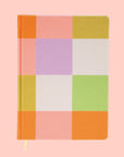 On a white background is a multi colored pastel checkered print jumbo journal.