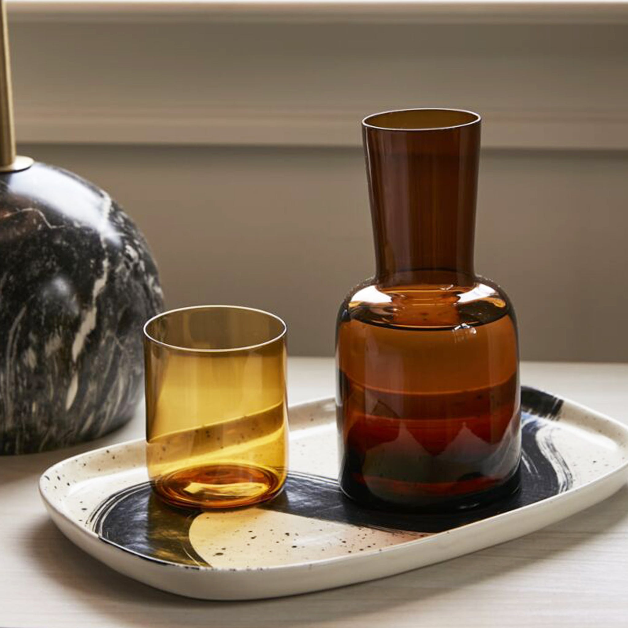 An amber glass carafe with a lid that doubles as a drinking glass.