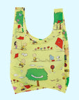 A yellow nylon reusable bag with a Charlie Brown kite eating tree print.
