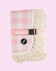 A pink and white checkered picnic blanket with a fringe edge.
