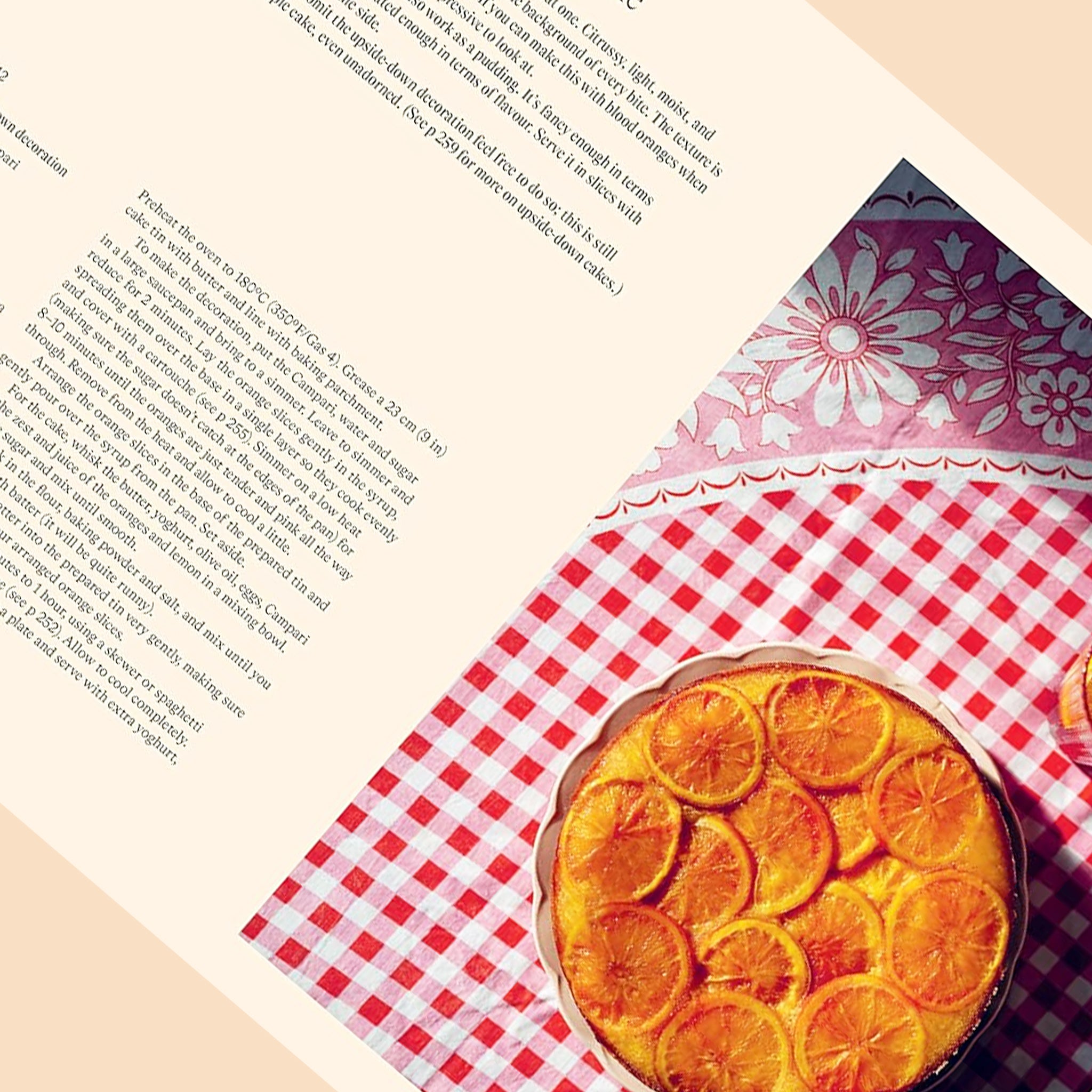 On a tan background is the book open to a page of the book with text on the left side and a citrus cake photograph on the right side. 