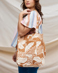 A tan and white canvas tote bag with a front pocket and a paisley pattern.