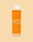 A bottle of orange body oil with white text that reads, 'Pamplemousse Replenishing Body Oil'.