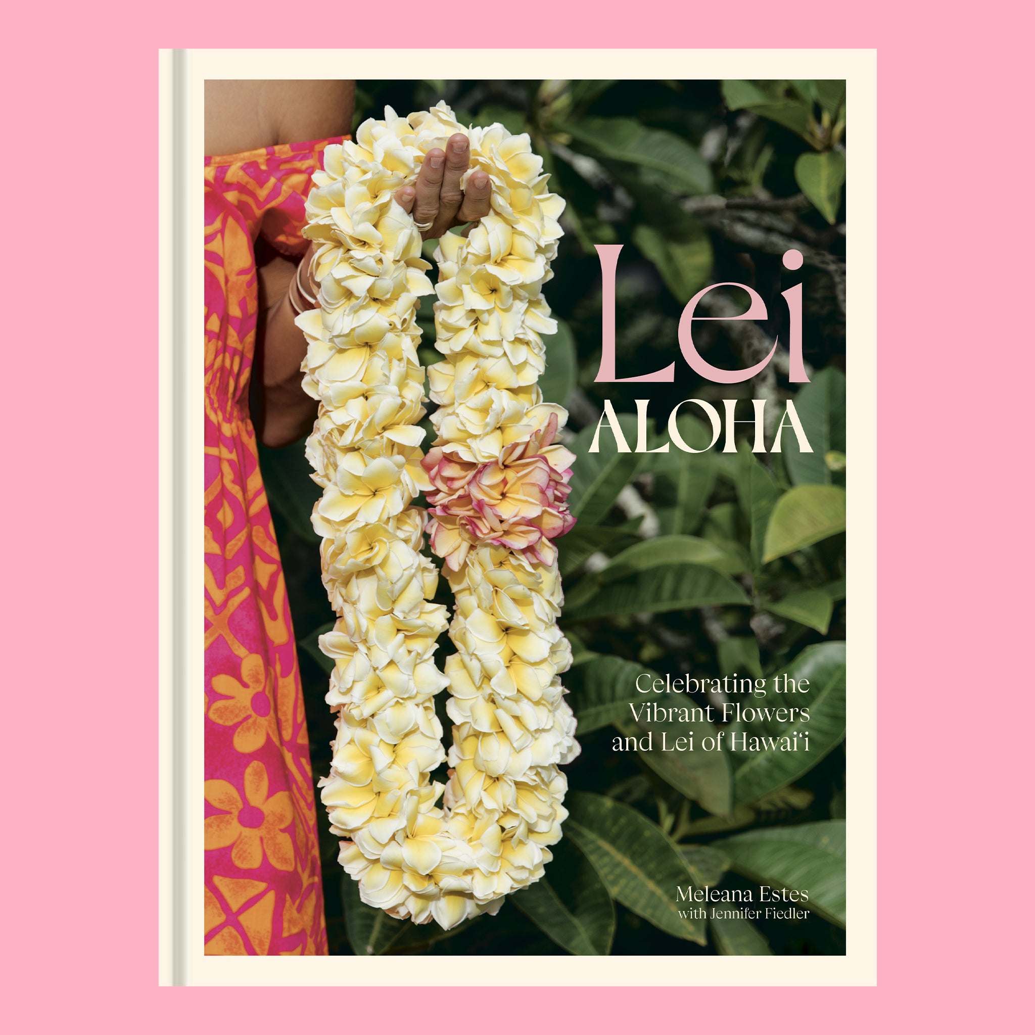 On a pink background is a book cover with green foliage and a model holding a lei along with the title of the book that reads, "Lei Aloha Celebrating the Vibrant Flowers and Lei of Hawai'i". 