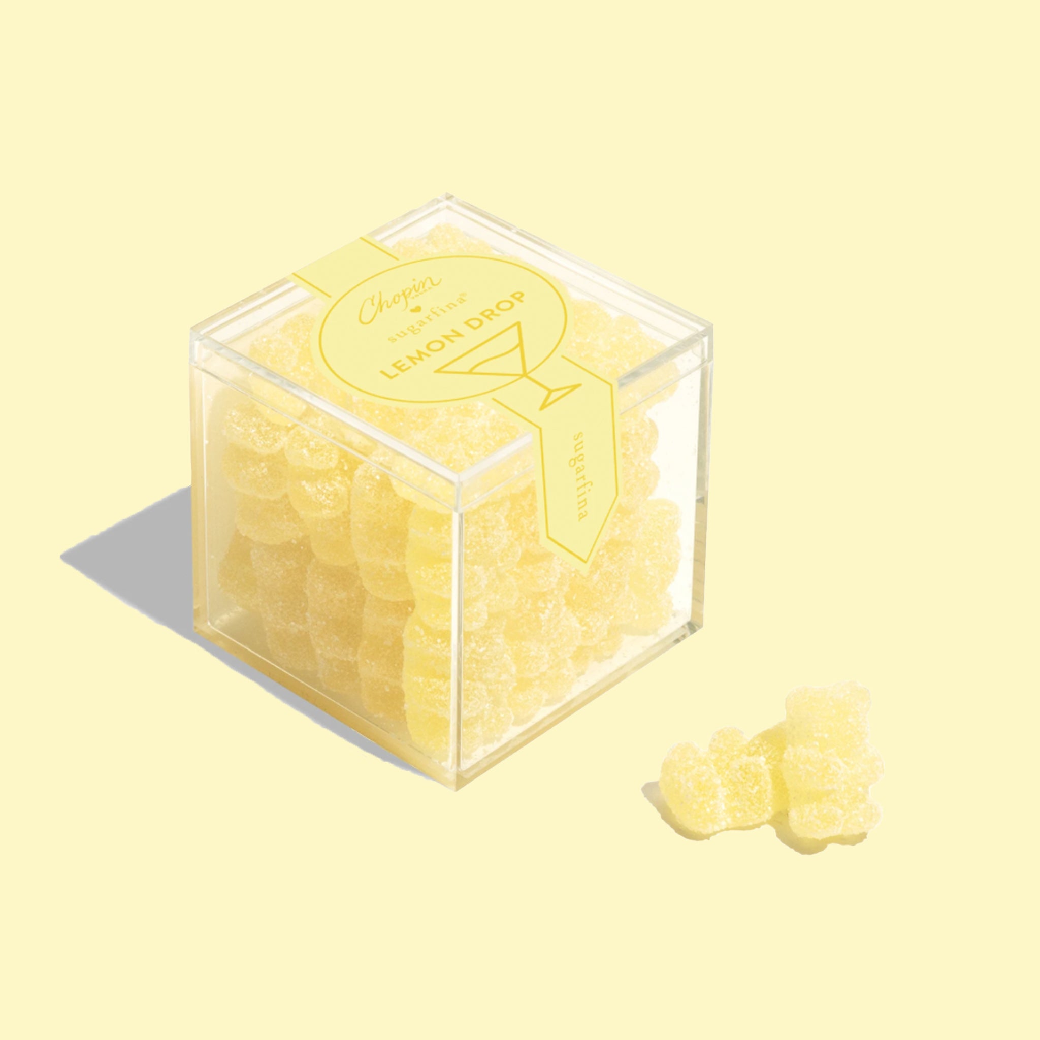 A clear acrylic box of yellow lemon drop flavored gummy bears. 