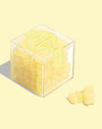 A clear acrylic box of yellow lemon drop flavored gummy bears.