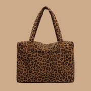 A brown and black leopard printed puffer carry on tote bag.