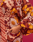 A rust, yellow and cream 70's inspired floral print linen robe.