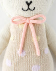 A neutral knit lamb stuffed toy.