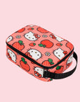 A pink and red lunch box with a Hello Kitty Apple pattern and black strap.