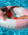 A pink and white striped pool float but the center is in the shape of a heart with a mesh backing.