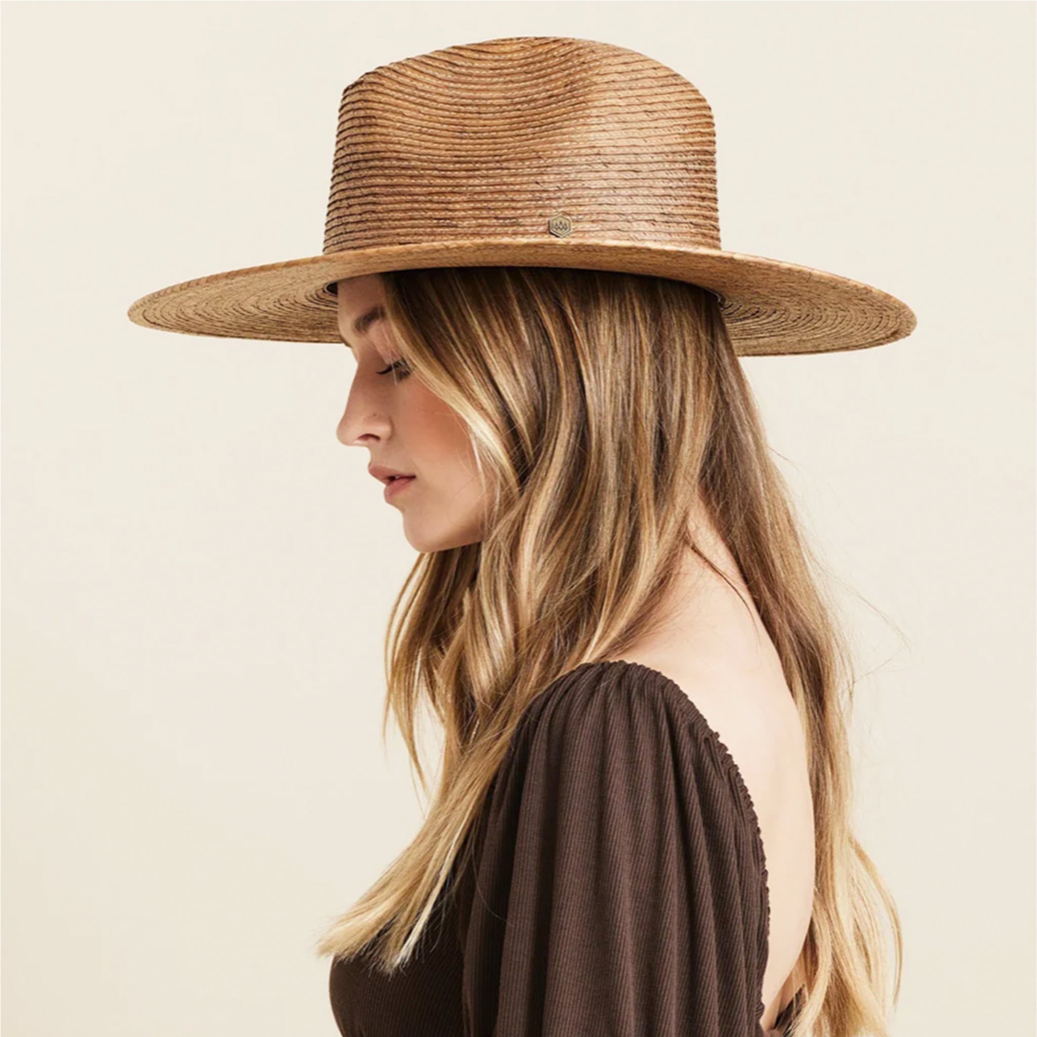 A neutral brown woven sun hat with a wide brim. 