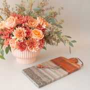 A wood and grey marble cutting board with a coordinating butter knife.