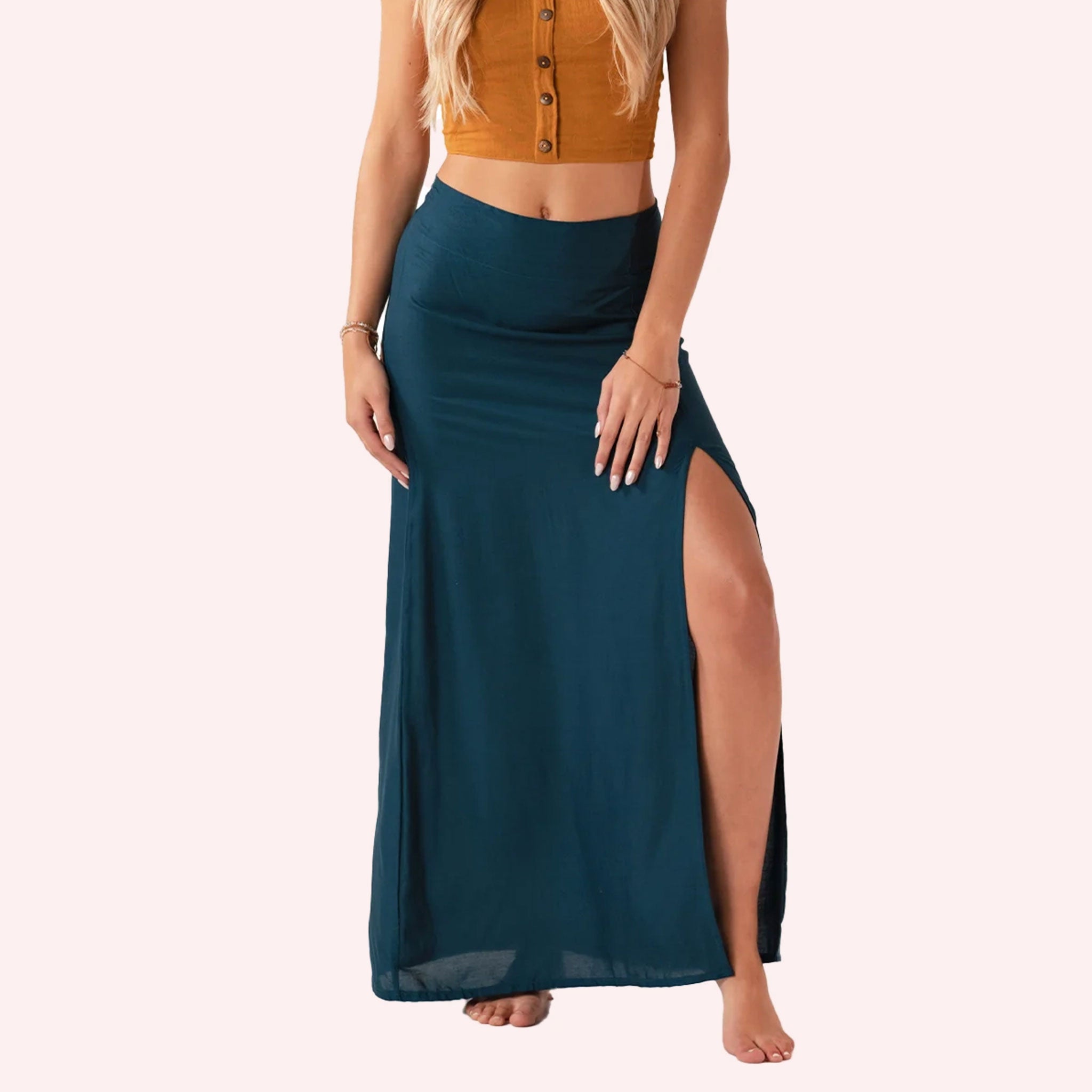 On a neutral background is a teal maxi skirt with a slit on the front side. 