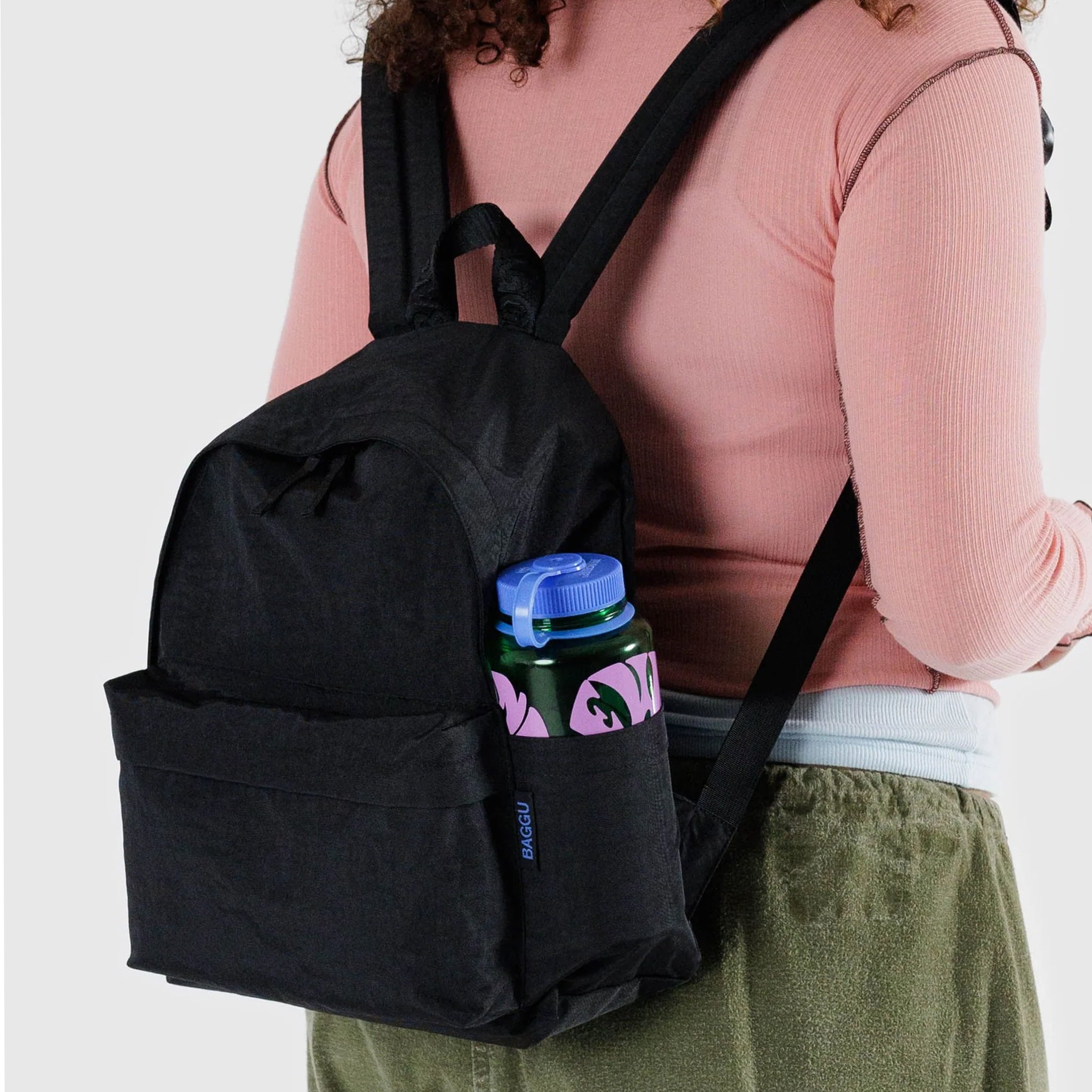 A black nylon backpack with two front zipper compartments and side pockets.