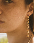 A pair of dangle chain earrings that have a sun shaped chain link.