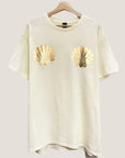 A short sleeved cream colored shirt with gold foiled shells on the chest area.