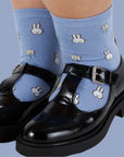A blue pair of crew socks with a white Miffy and flower pattern.