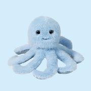 On a blue background is a light blue octopus shaped stuffed toy with a smiling face.