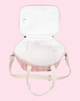 On a light pink background is a pink and white cooler bag with a long adjustable strap.