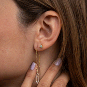 A model wearing a petite triangle stud earrings made with gold plating and a greenish amazonite stone.