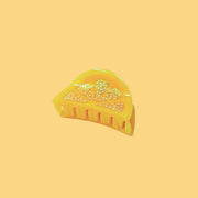 A mini lemon slice shaped hair claw clip.