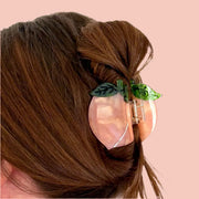 A mini peach shaped hair claw clip.