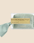 A sage velvet pouch filled with 21 wedding day essentials for brides.