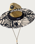 A black and ivory monster printed straw hat with a drawstring knot neck strap.