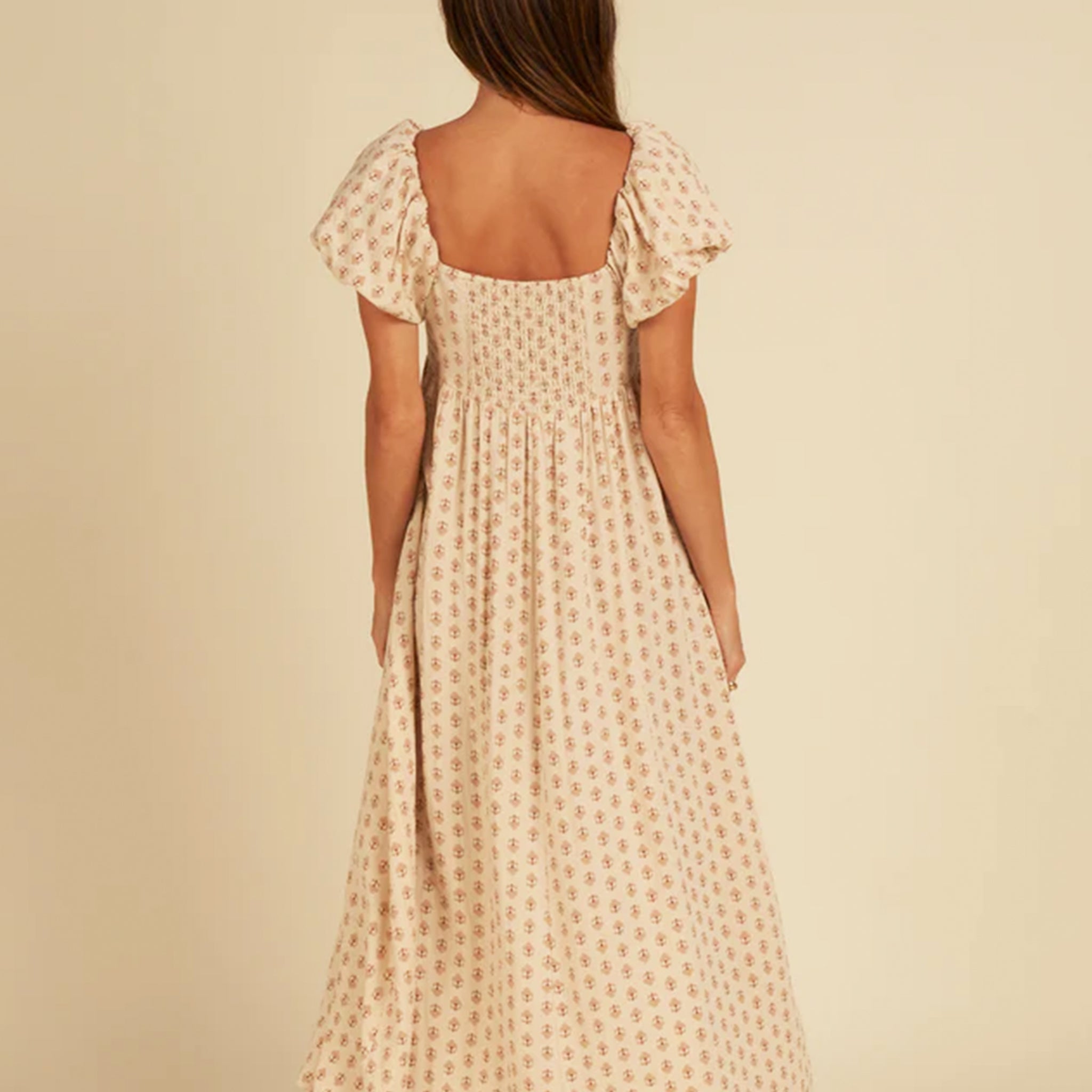A neutral colored vintage floral print maxi dress with a square neckline and puffy short sleeves.