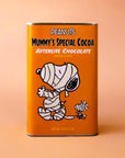 An orange rectangle tin of hot chocolate mix with a graphic of the Snoopy character wrapped up like a mummy and text that reads, 'Peanuts Mummy's Special Cocoa Afterlife Chocolate'.