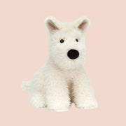 A cream colored scottie dog shaped stuffed toy.