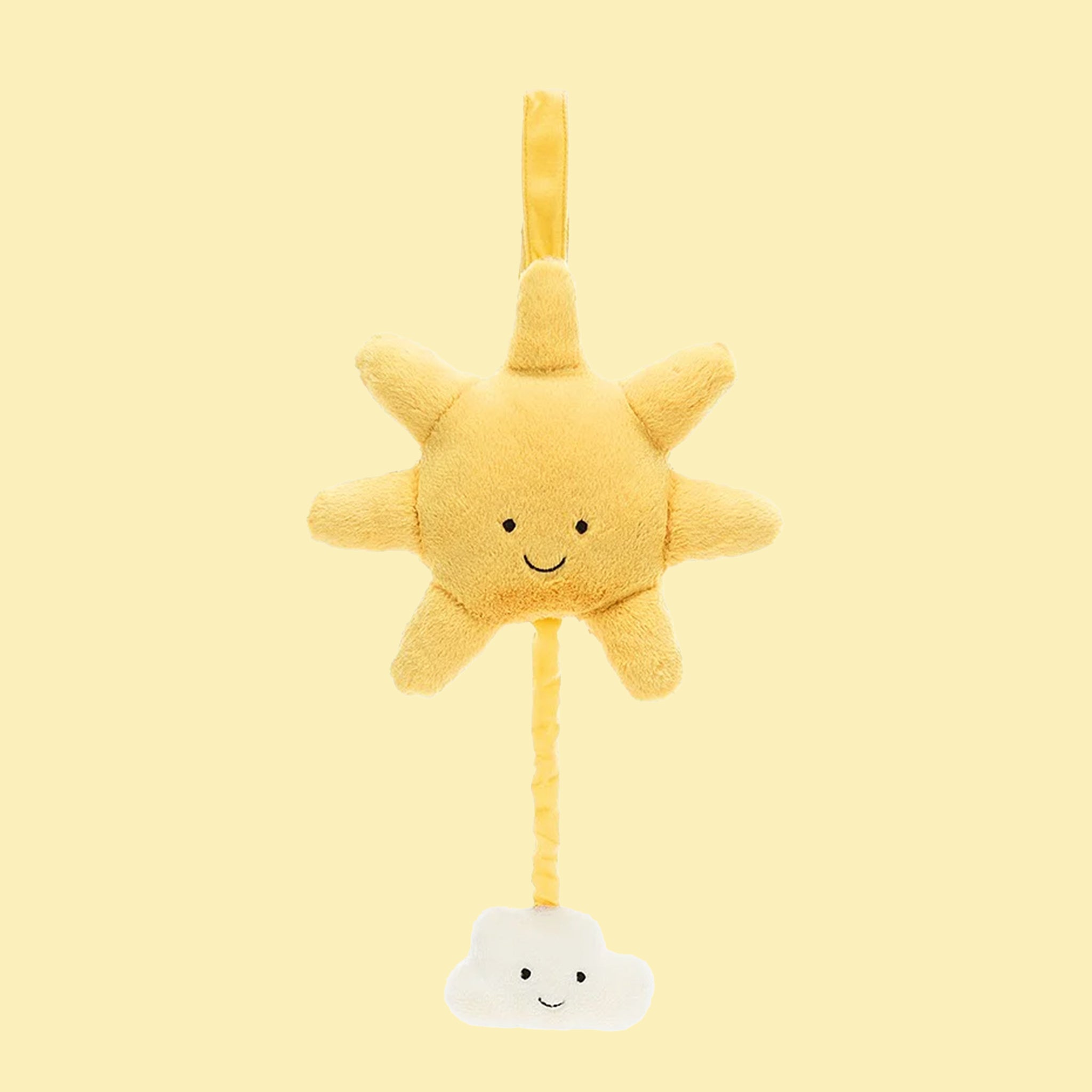 On a yellow background is a yellow sun and cloud shaped stuffed toy with a retractable pull and velcro loop for hanging.
