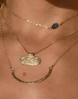 A gold filled crescent shaped necklace.