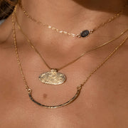 A gold filled crescent shaped necklace.