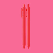 On a pink background is a pair of hot pink / red pens. 