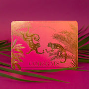 A pink and orange ombre card with gold foiled text and design of monkey's in jungle foliage cheersing champagne flutes and text that reads, "Cheers to the Newlyweds Congrats".