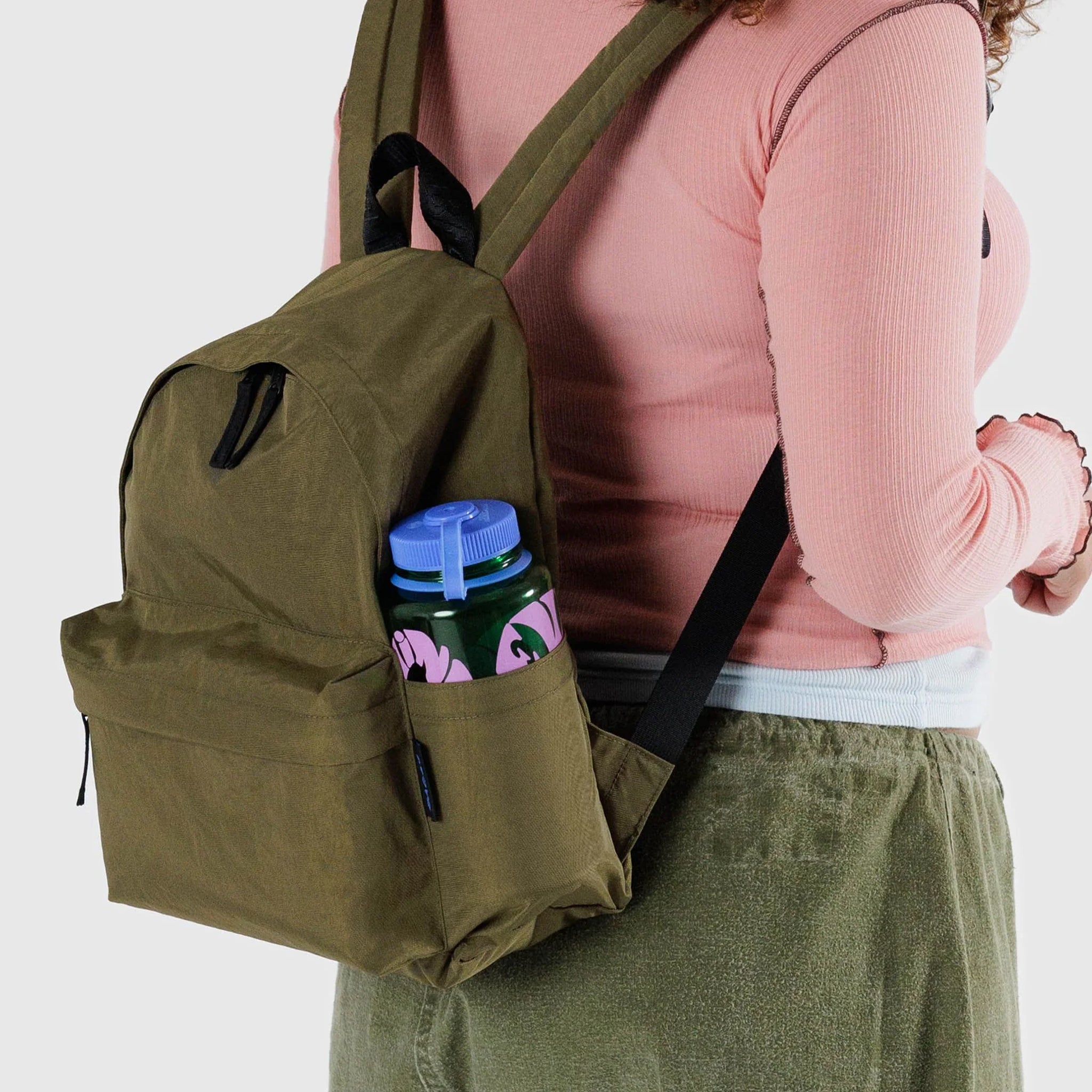 A dark green nylon backpack with side pockets, two front zipper compartments and black straps.