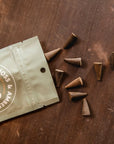 A bag of 20 incense cones in a neutral packaging with text that reads, 'Oakmoss & Amber Incense Cones'.